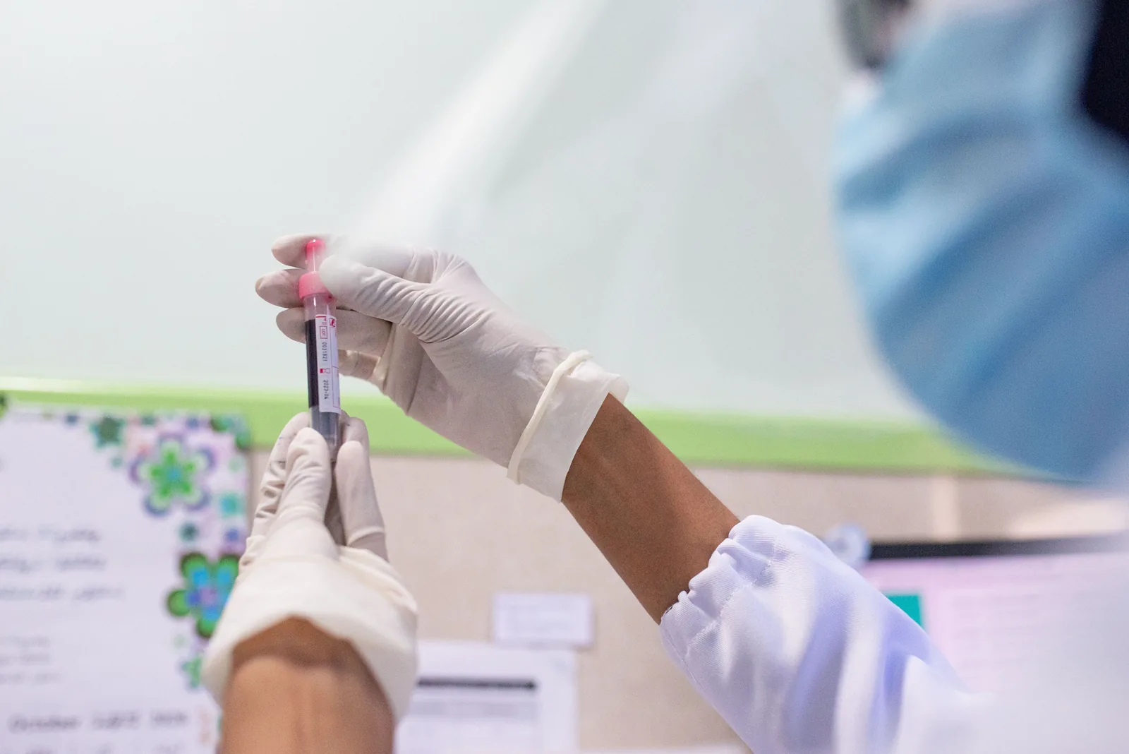 Healthcare professional examining a laboratory blood sample