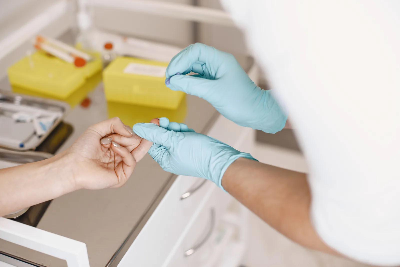 A healthcare professional performing a small blood sample test